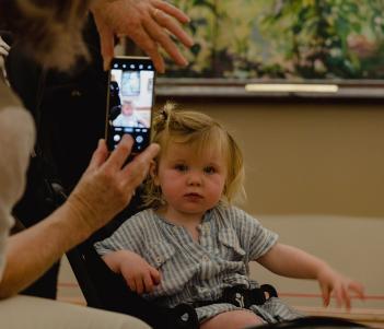 A toddler in a buggy getting her photo taken  in the Gallery