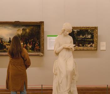 Woman looking at a painting in a gallery