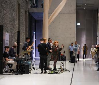 A band performing in the courtyard area with a rapt audience looking on