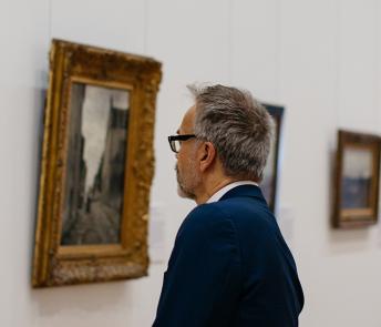 Man looking at a painting in the Millennium Wing of the National Gallery of Ireland.
